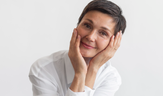 Mujer adulta con piel luminosa tras tratamiento de rejuvenecimiento facial natural con ácido hialurónico y toxina botulínica en Mallorca.